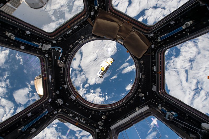 A lego astronaut in space and view of planet earth from the international space station.