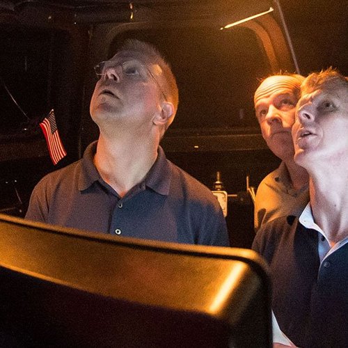 Astronaut Tim Peake and companions look up at the night sky in wonder.